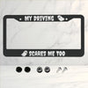 A black license plate frame with the text My Driving scares me too and a ghost design on a white marble background.