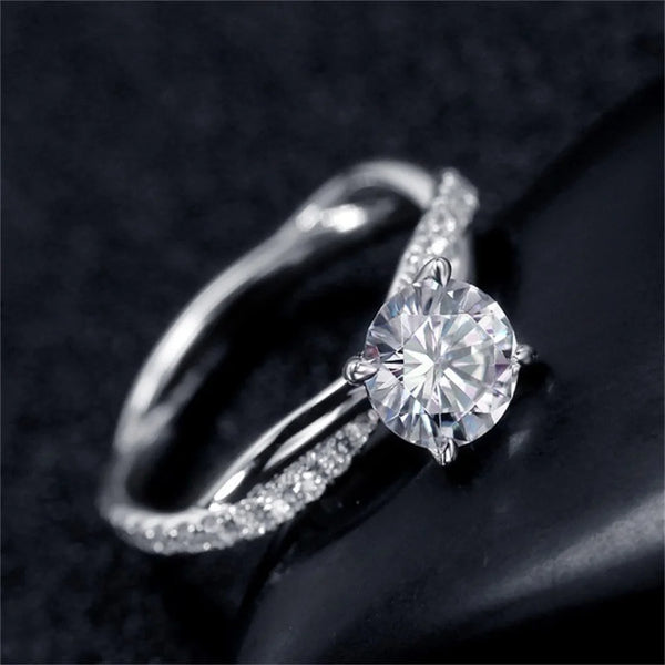 A close-up shot of a two-tone princess cut CZ engagement ring on a finger against a dark background.