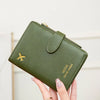 A green leather passport wallet with RFID blocking features and card slots is shown being held by hands.