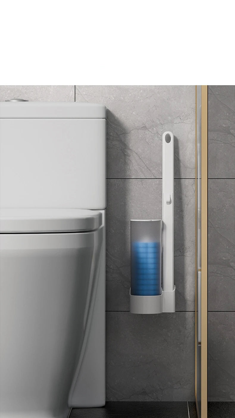 A white disposable toilet brush set with a wall-mounted holder is shown next to a toilet.