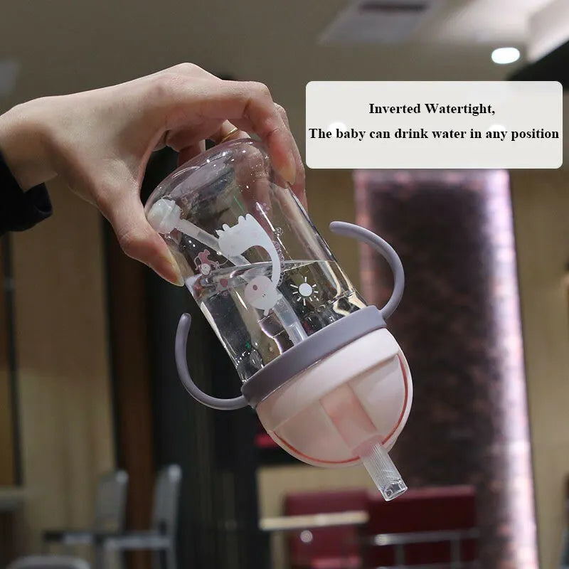 A hand holds an inverted water tight, a sippy cup designed for babies to drink water in any position.