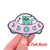 A pink and green embroidery patch featuring a cartoon cat inside a stylized, round design.