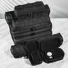 A stack of black portable leather watch travel cases with soft lining displayed on a white marble surface.