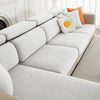 A modern white sofa with light gray cushions and orange accent pillows.