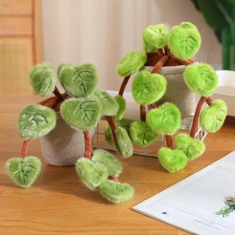 A set of lifelike plush green pothos plants in terracotta pots with brown stems and leaves on a wooden surface.