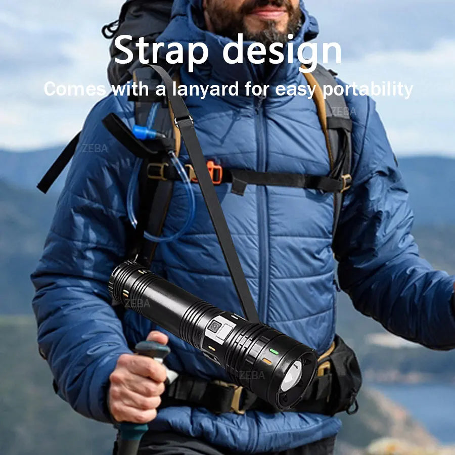A person wearing a blue jacket is holding a black flashlight with a lanyard for portability.
