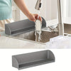 A flexible silicone sink splash guard with a suction base is being used to direct water into a kitchen sink.