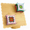 Holz-Strick-Blockierbrett-Set mit zwei fertigen granny squares in verschiedenen Farben.