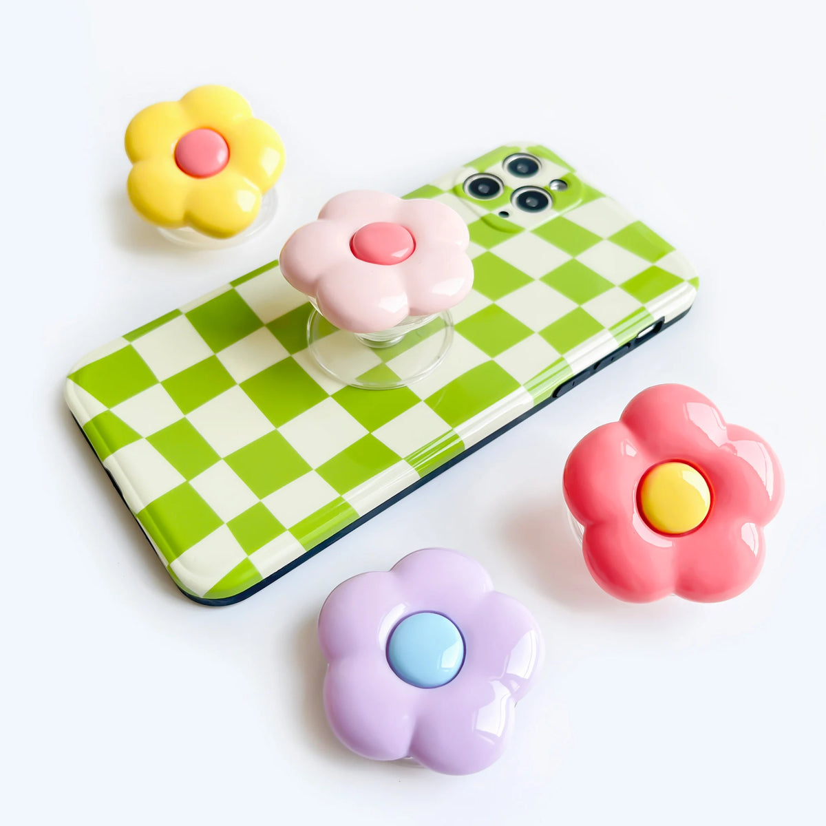 A foldable phone grip stand featuring colorful, squishy flower-shaped silicone grips in yellow, pink, and purple.