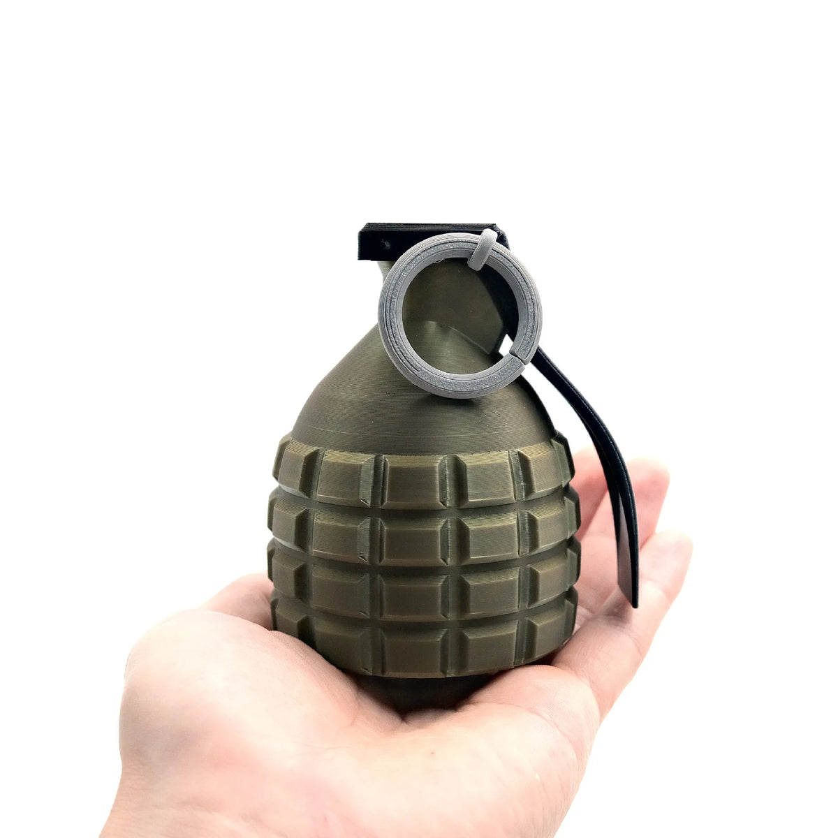 A hand holds a universal 50mm tow ball cover protector, which is a dark olive green, conical object with a silver loop on top