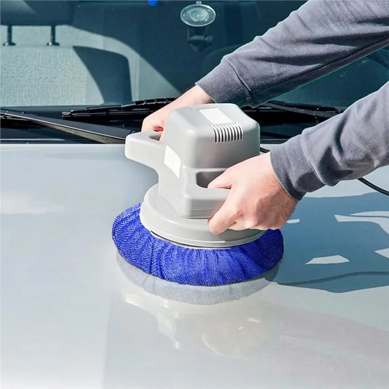 A person is using a gray car polishing pad set with blue microfiber and wool bonnets on a silver car surface.