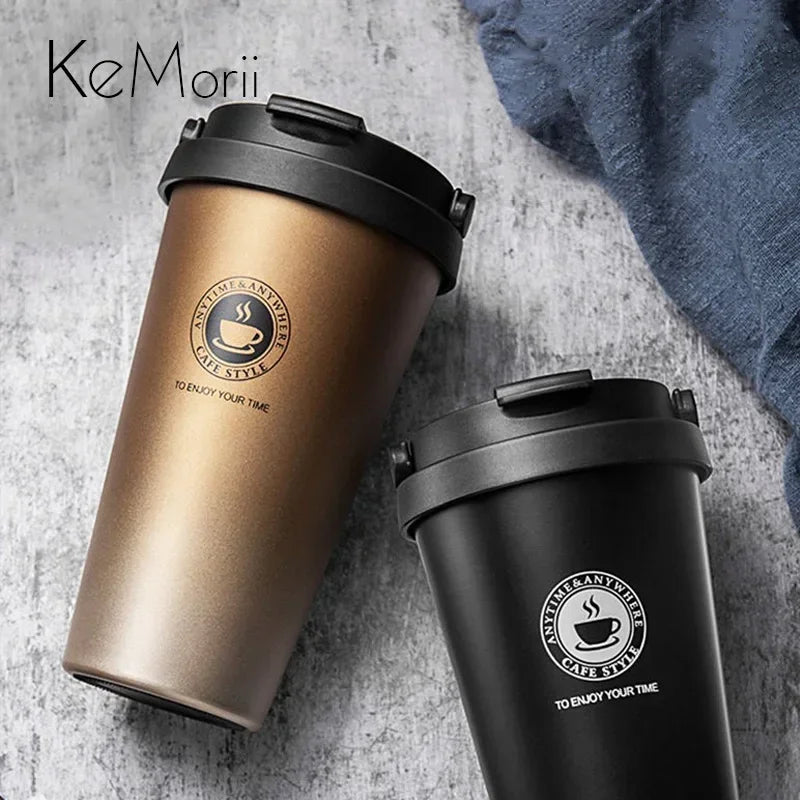 Schwarze und kupferfarbene isolierte Reise-Kaffeebecher auf grauem Untergrund.