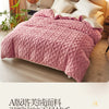 Pink quilted velvet duvet cover and blanket displayed on a bed in a bright room.