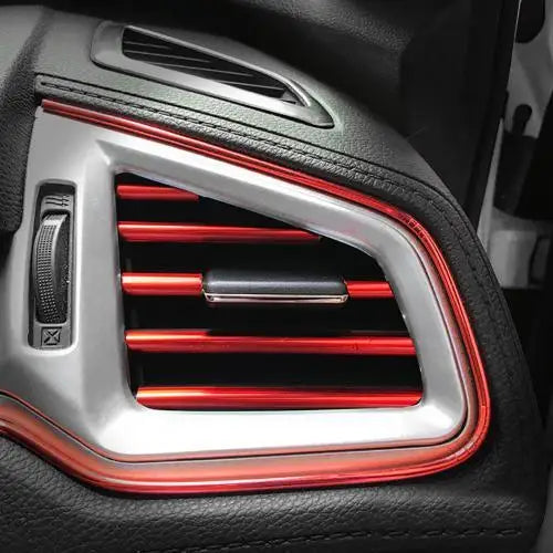Close-up of flexible car interior trim strips featuring a silver surround and red accent lines.