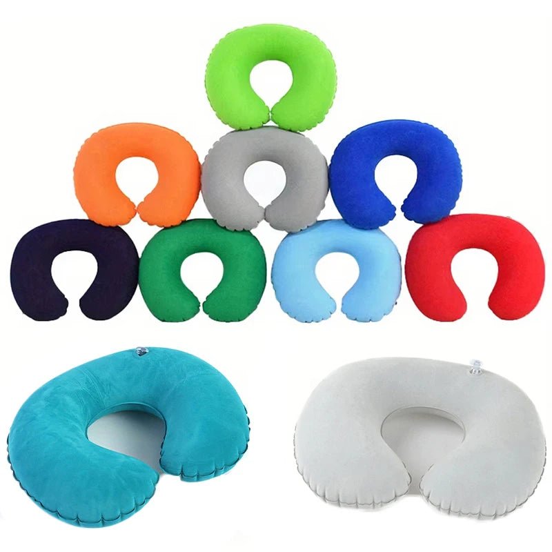 A collection of inflatable U-shaped travel neck pillows in various colors including green, orange, blue, red, and light blue/