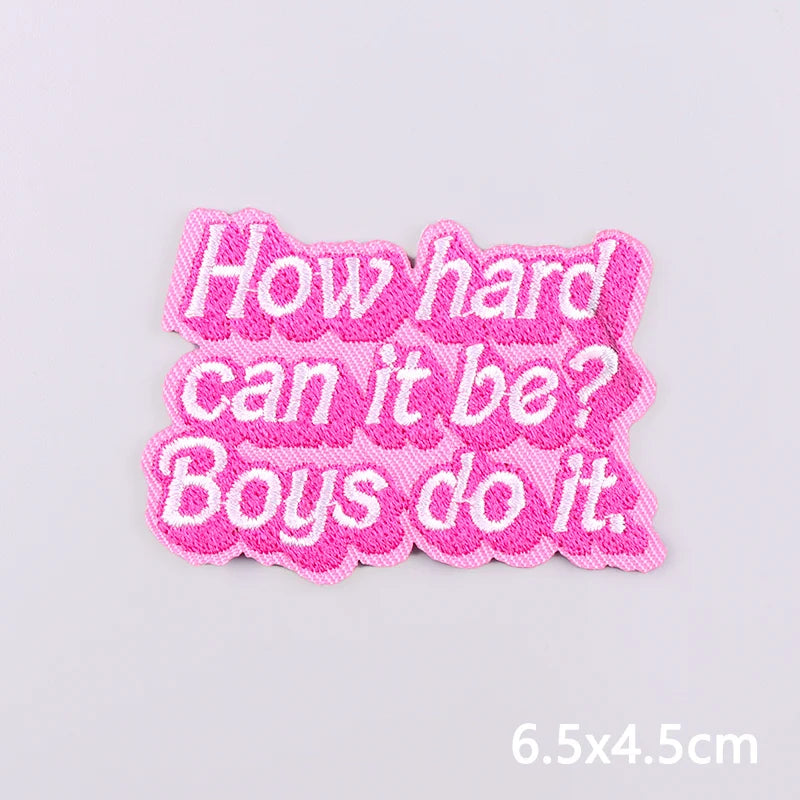Pink embroidered iron-on letter and word patches spelling out How hard can it be Boys do it.