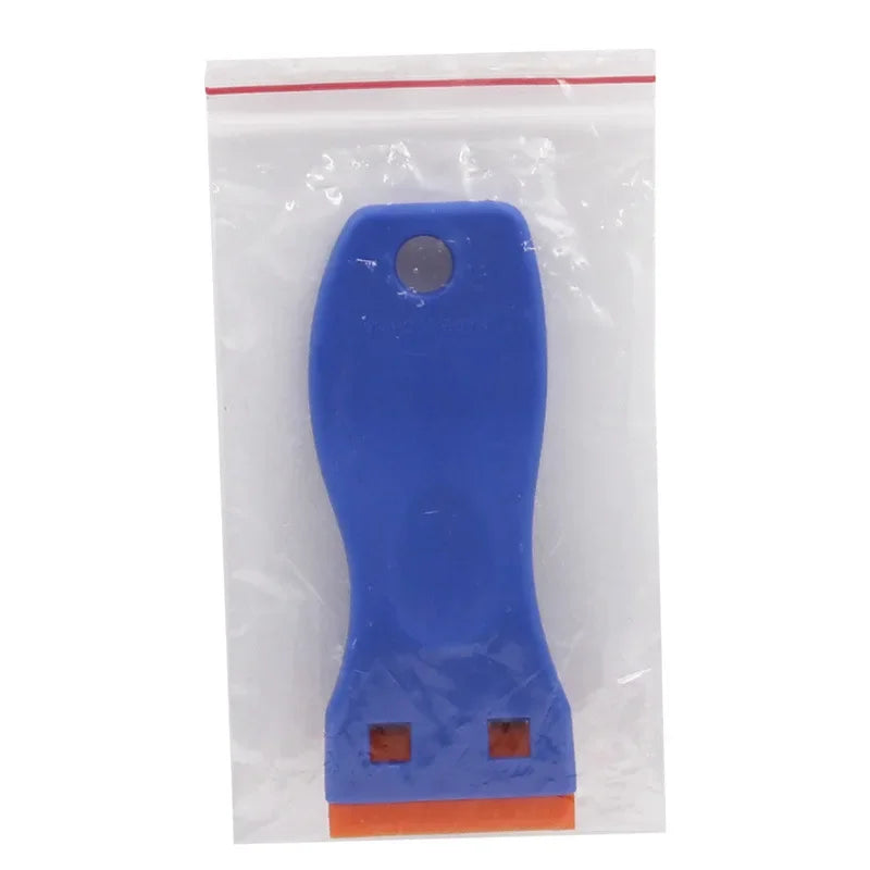 A blue plastic razor scraper with an orange base and a silver replacement blade visible inside a clear plastic pouch.
