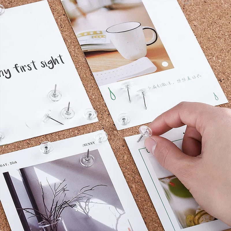 A hand is placing a clear push pin into a card featuring a photo and text.