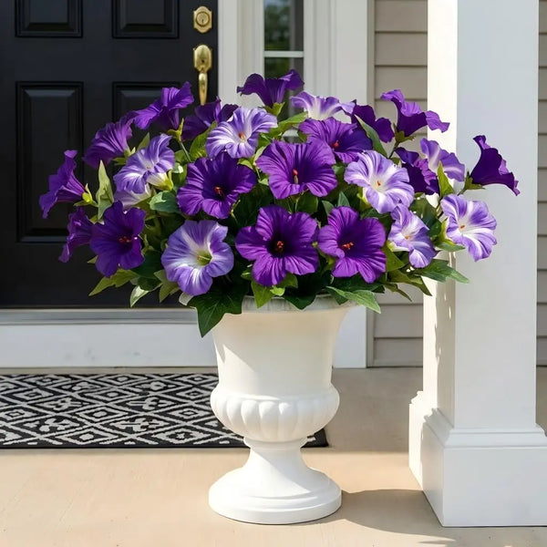 A vase of vibrant purple and white UV-resistant artificial petunia flowers displayed on a porch