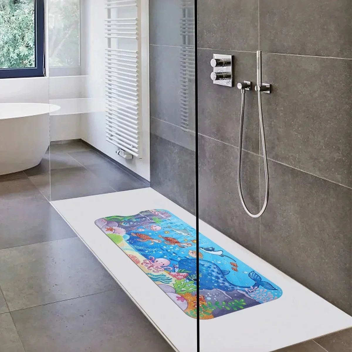 A colorful cartoon bathtub mat with sea life is displayed on a white tray in a modern bathroom setting.