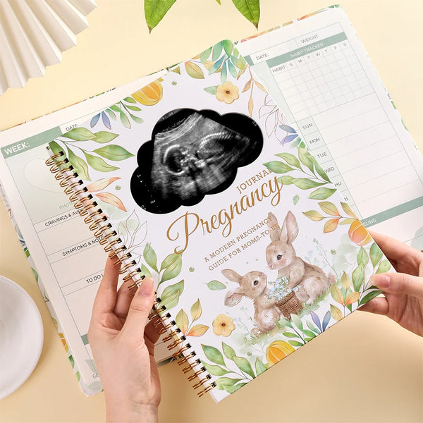 Spiralgebundetes Schwangerschaftsjournal mit Raster und monatlichen Kalendern mit floralen Illustrationen.