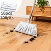 A white disposable electrostatic broom cover is shown on a wooden floor next to a cleaning mop.