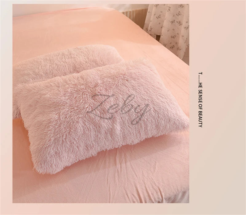 A pink fluffy pillow resting on a light pink bed with a white patterned sheet.