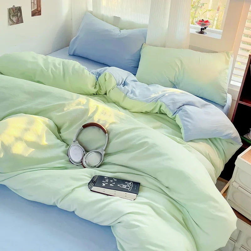 A light green cotton bedding set featuring a flat sheet, duvet cover, and pillowcases on a bed.