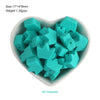 A pile of turquoise silicone crown star heart beads in a white dish.