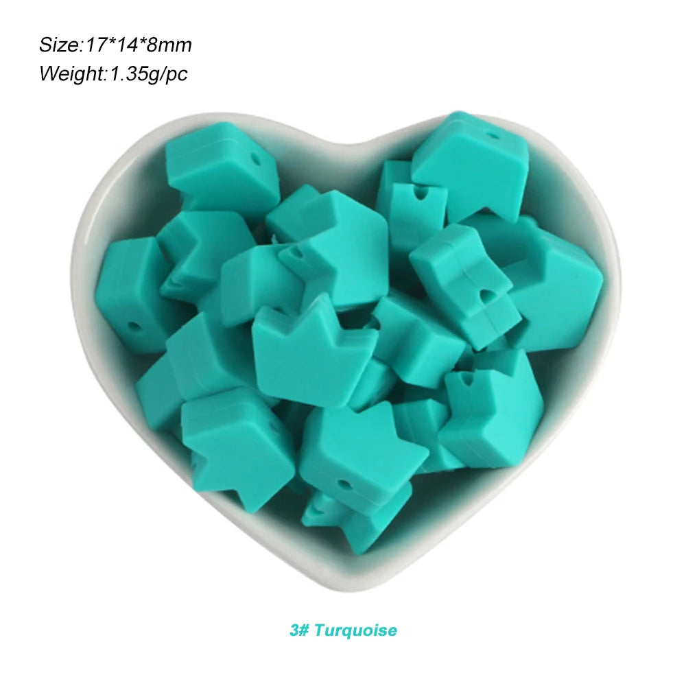 A pile of turquoise silicone crown star heart beads in a white dish.