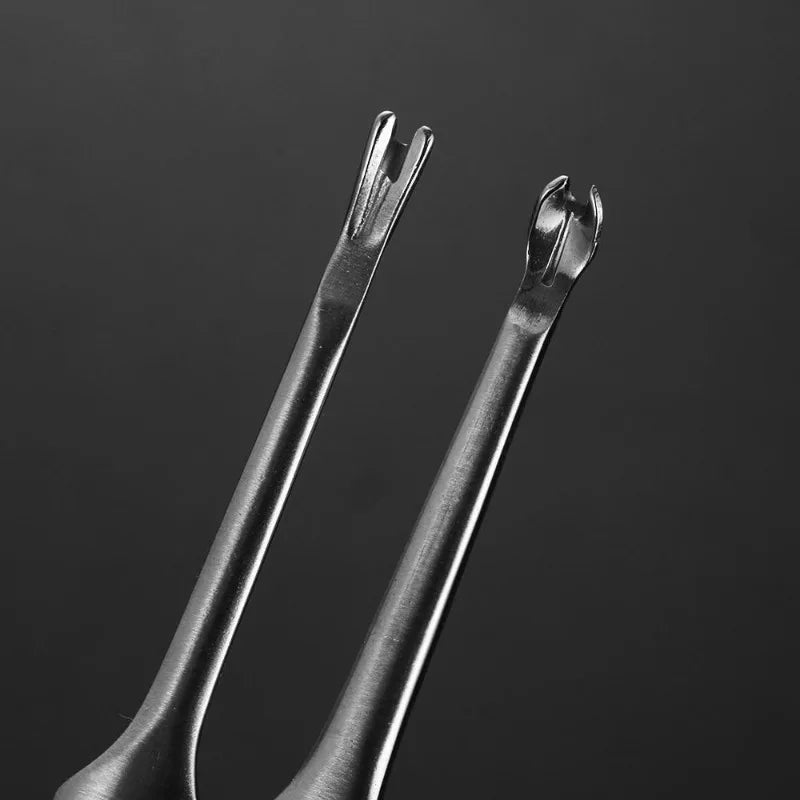 A pair of metal leather edge groover and beveler tools against a dark background.