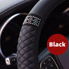 Black breathable faux leather steering wheel cover with diamond accents on a car steering wheel.
