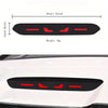 Black brake light sticker with red markings applied to a white car body panel.