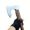 A hand-forged Viking tomahawk axe with a light blue blade being held by a hand in a black glove.