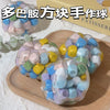 A collection of colorful squishy stress balls in various pastel shades resting on a wooden board.