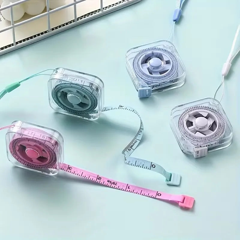 Una cinta métrica retráctil de plástico transparente con escala rosa y blanca, junto a dos dispositivos similares.