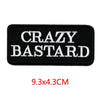 Black embroidered iron-on letter patch with white text CRAZY BASTARD