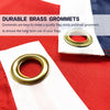 Close-up of a brass grommet used to attach a flag, shown on red and white fabric.