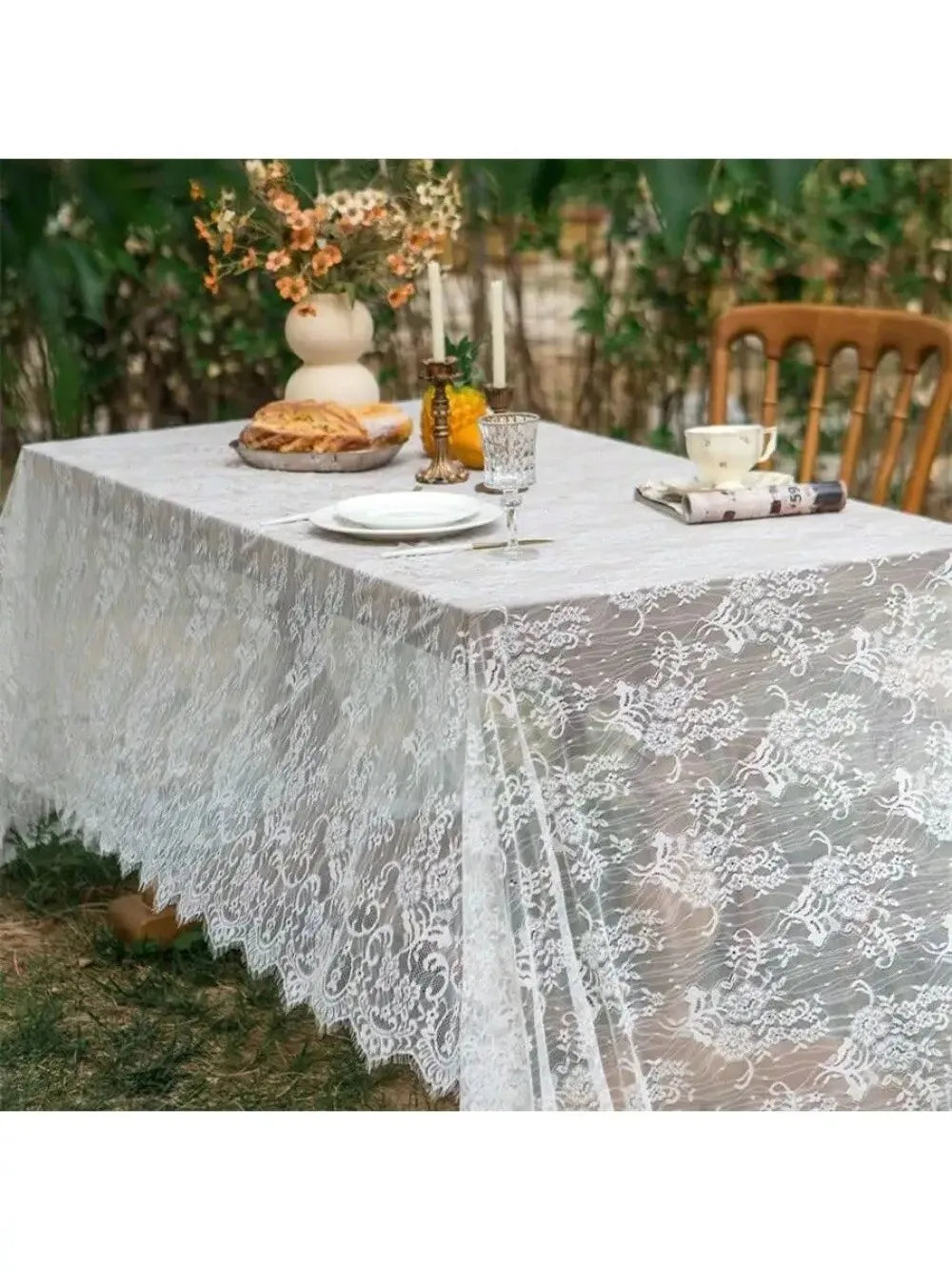 Elegant white lace tablecloth with French retro floral design set for a wedding or party.