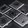 A collection of classic stainless steel cigarette cases with various embossed patterns and designs.