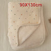 A beige floral muslin baby blanket with a ribbed edge is shown folded on a light background.