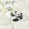 A white quilted fabric features a cute panda design with bamboo stalks and green leaves.