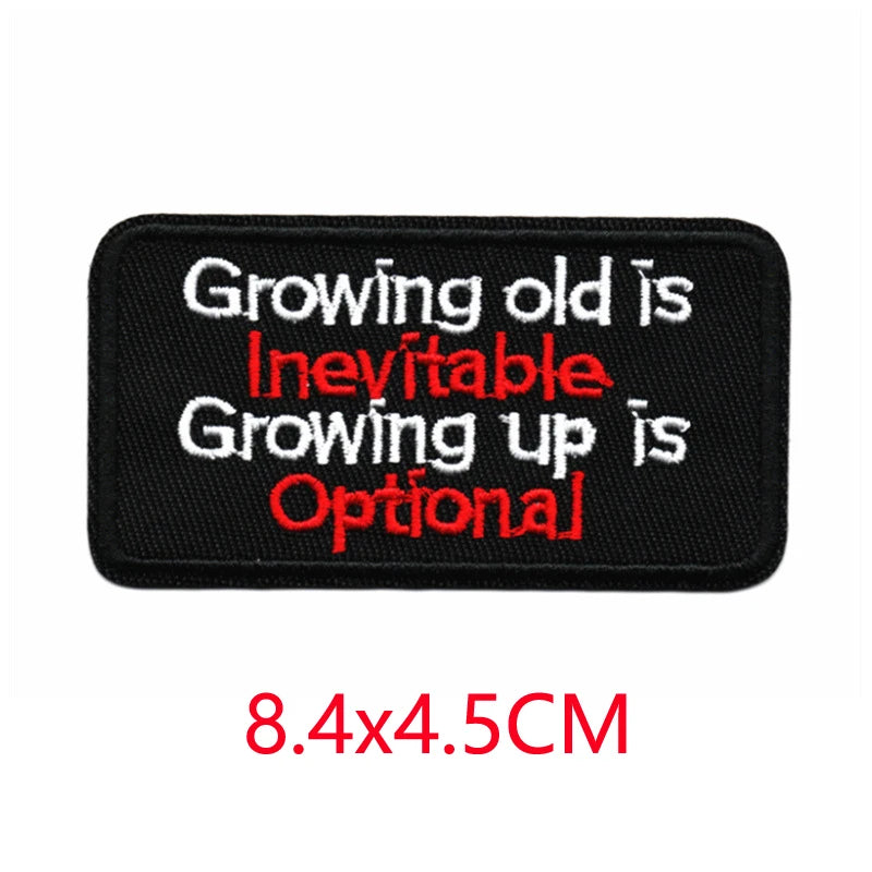Black iron-on letter patch with red embroidered text that reads Growing old is inevitable Growing up is optional