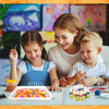 A young girl and boy are painting flowers on a plate using a water marbling kit with various supplies.