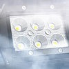 A close-up view of an 18W LED flood light pod pack with four bright lights inside, surrounded by mist.