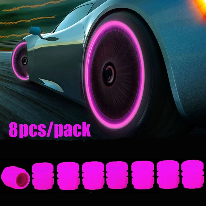 Eight luminous pink tire valve caps with a glow-in-the-dark design shown in a close-up on a car wheel.