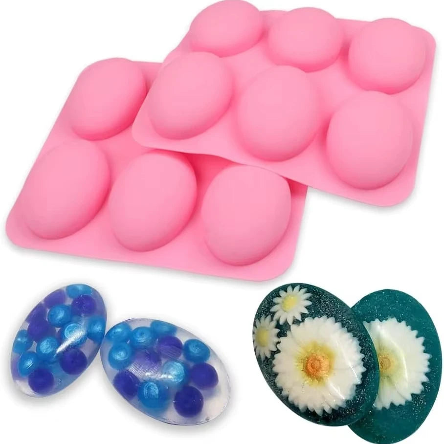 Pink silicone mold tray with six cavities and several oval blue and green glass beads