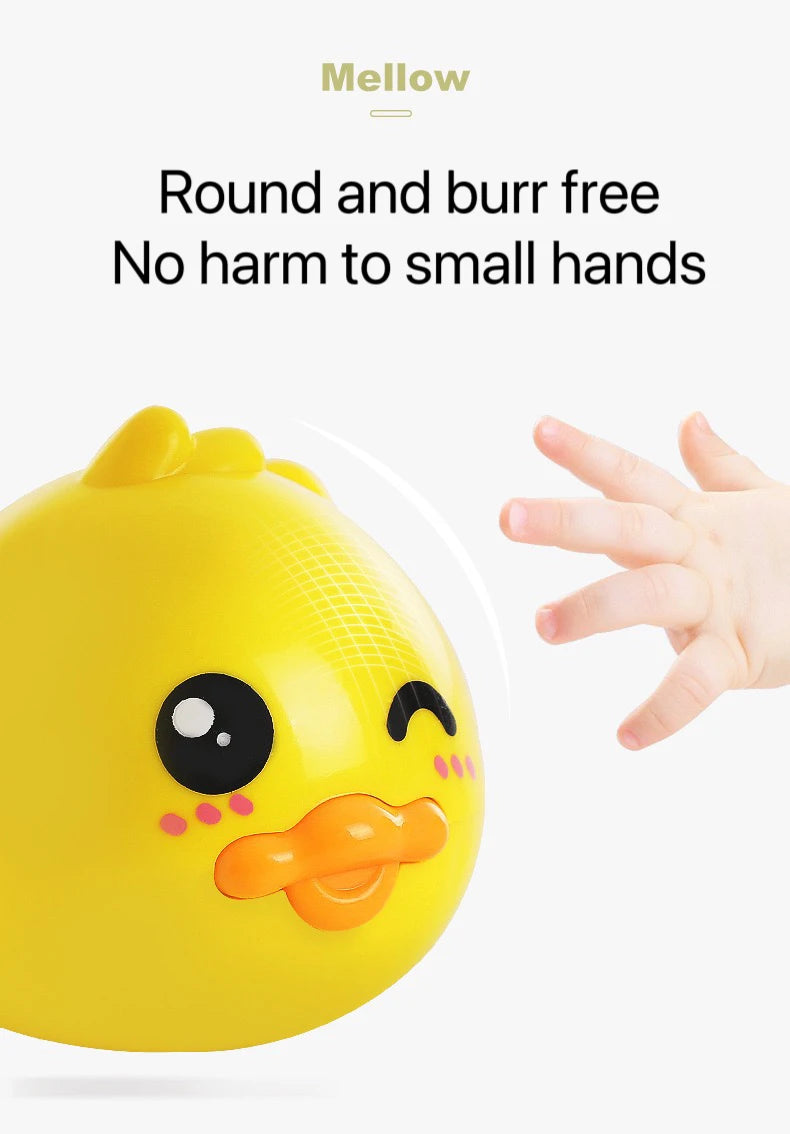A yellow wind-up bath toy duck with a smiling face is shown next to a hand.