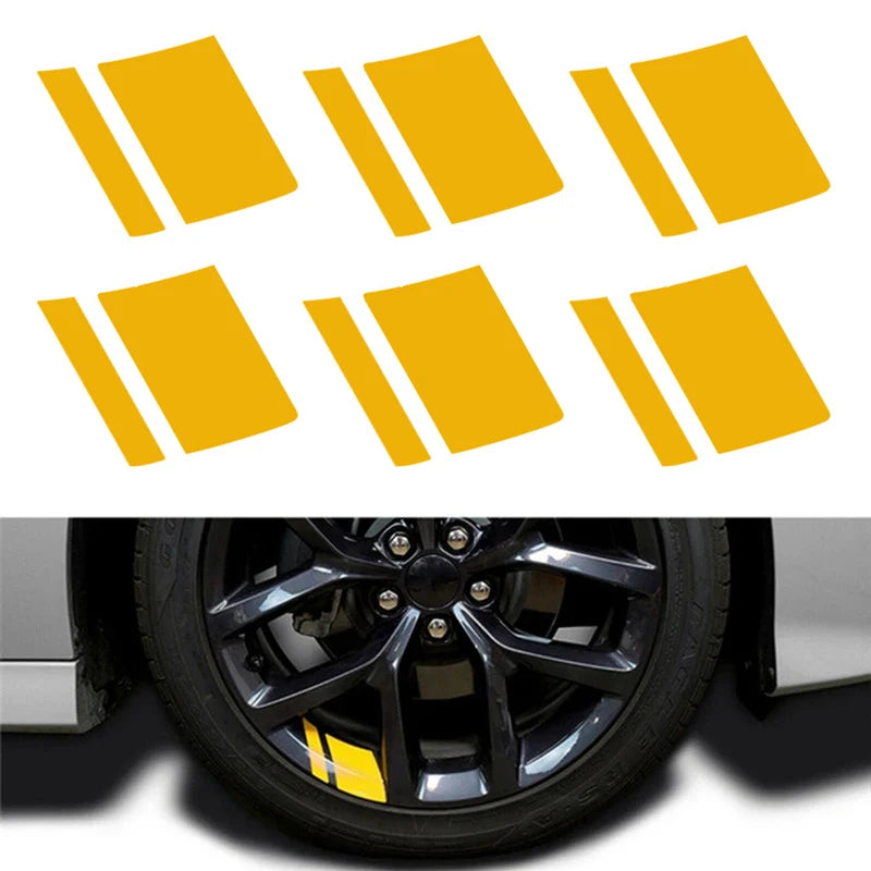 A set of six yellow reflective stickers placed on a car wheel hub.