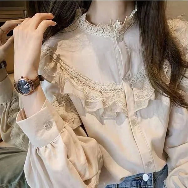 A close-up of a woman wearing a cream vintage lace long sleeve blouse with a high neckline and detailed embroidery.